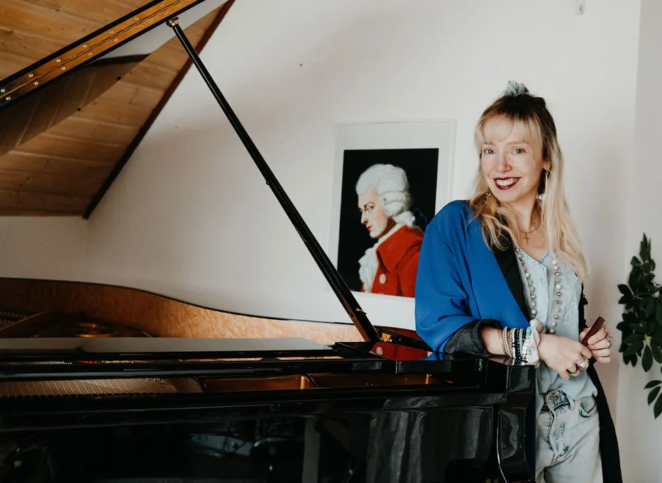 Miriam Geissler steht lächelnd an einem geöffneten Flügel